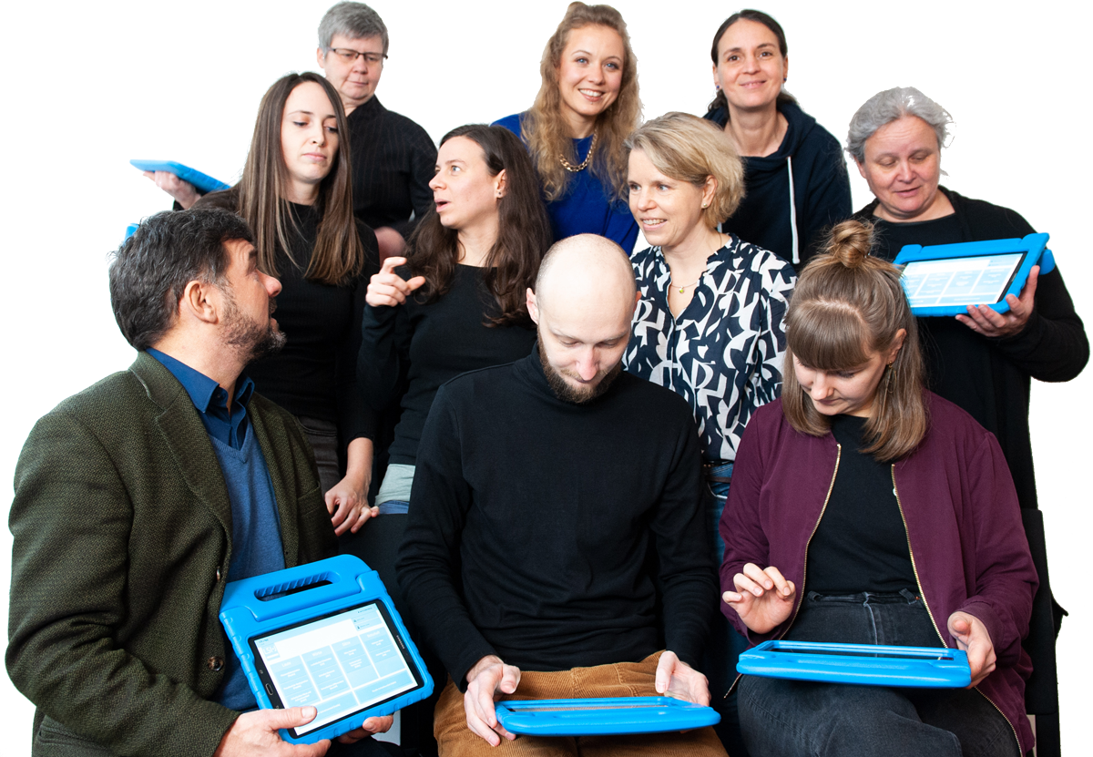 Gruppenbild mit 10 Personen aus dem DINKO-Team. Die meisten haben LSI.J-Tablets in der Hand, einige reden miteinander.